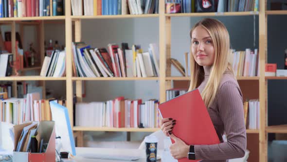 Beautiful Girl - an Office Employee - Looks at Camera and Smiles