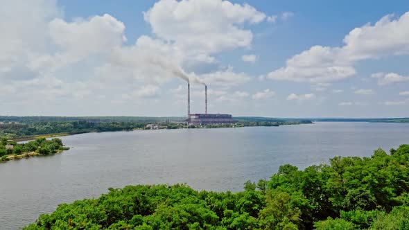 River view from above and two pipes of factory plant. Smoke from the pipes of power plant station