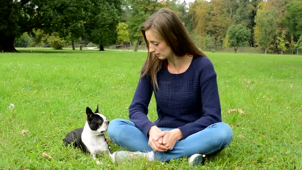 Young Attractive Happy Woman Sits in the Park with Her French Bulldog - They Take Rest Time