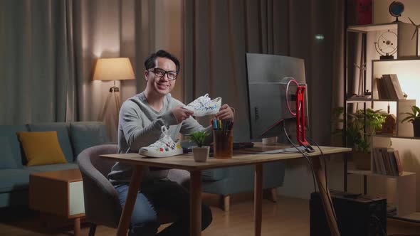 Asian Male Footwear Designer Smiling To The Camera While Working On A Desktop Computer At Home