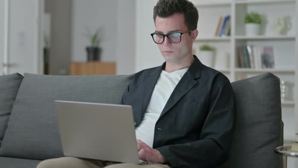 Young Male Designer Working on Laptop at Home 