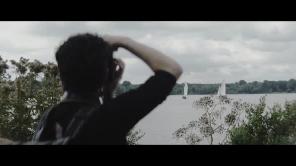 Man taking pictures of boats sailing in a lake