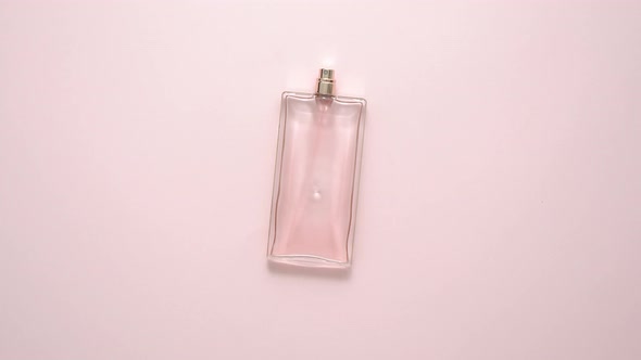 Top View of Luxury Bottle of Perfume on Pastel Pink Surface. Minimal Composition. Flat Lay