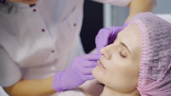 A Specialist in Aesthetic Cosmetology Holds a Syringe in Her Hand 