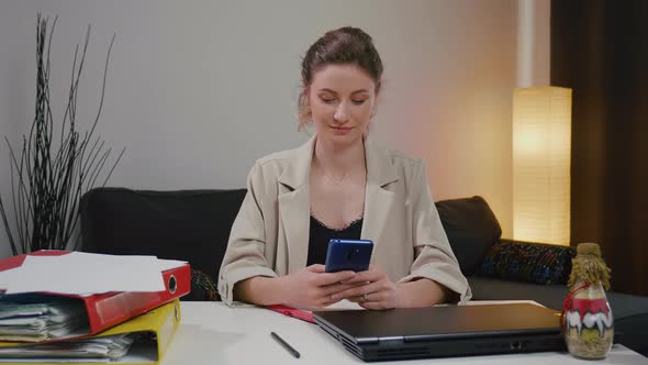 Woman using smartphone after a successful day's work.