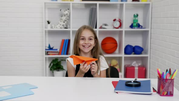 Laughing Kid Having Fun Throwing Paper Plane at School Lesson in Classroom Back to School