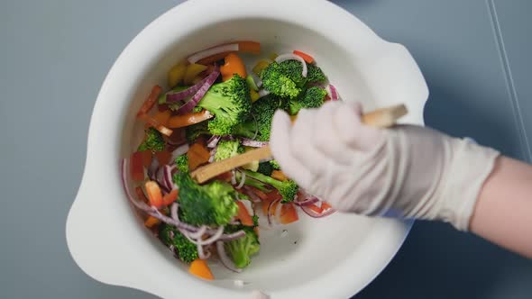 Person in White Gloves Mixes Delicious Vegetarian Salad