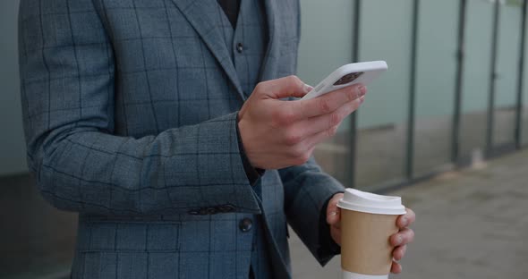 Close Up of Businessman's Hand Using Mobile Phone Surfing Internet with Smartphone and Holding