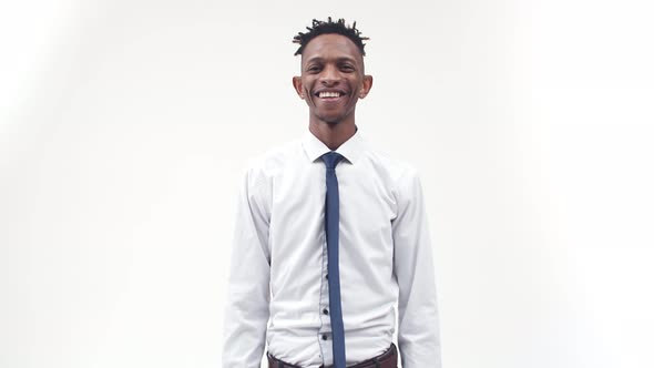 An AfricanAmerican Man in Shirt Smiles and Nods His Head Against a White Background