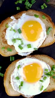 Fried Egg Sandwich with Yolk on Toasted Slice of Bread Sprinkled with Green Onions