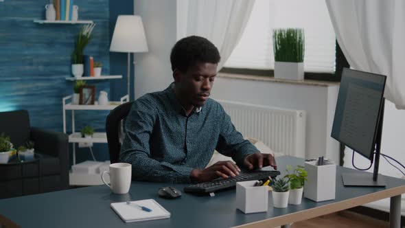 Black Man Computer User Working From Home in Cozy Flat