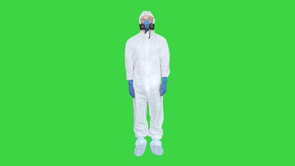 Man in Protective Suit, a Mask and a Respirator Thumbs Up on a Green Screen, Chroma Key.