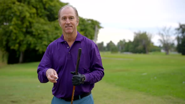 Man Smiling And Showing A Golf Ball