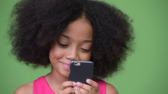 Young Cute African Girl with Afro Hair Using Phone