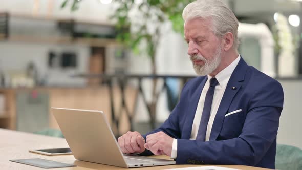 Old Businessman with Laptop Showing Thumbs Up