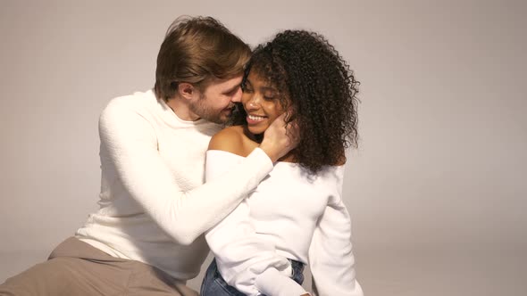 Smiling beautiful woman and her handsome boyfriend posing in studio