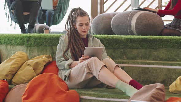 Woman Working on Tablet in Modern Coworking Space