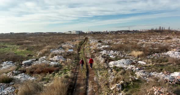 Two People Walking on a Huge Aste Garbade Dump Rubbish Landill in Bucharest