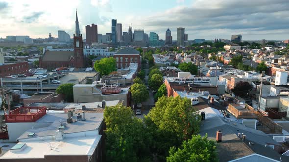 Rising aerial reveal of Baltimore MD skyline. Maryland city seen from Federal Hill neighborhood comm