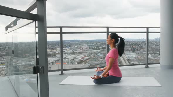 Woman meditating in balcony at home 4k