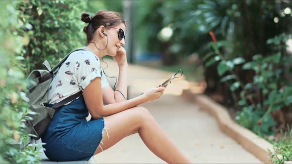 Young Beautiful Woman Listening to the Music Dancing and Singing in the Park