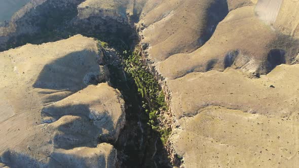 Aerial Deep Long Rift Canyon with Cleft Steep Rock Walls and High Cliff Gorge