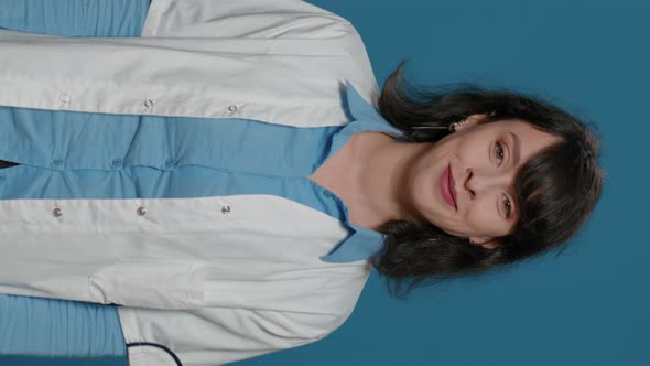 Vertical Video Portrait of Female Chemist with White Coat Standing in Front of Camera