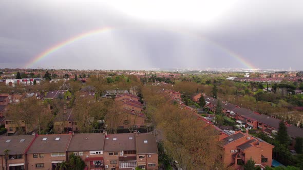 Full rainbow after a stormy day over suburbs in Pozuelo, Madrid, Spain. Fly over