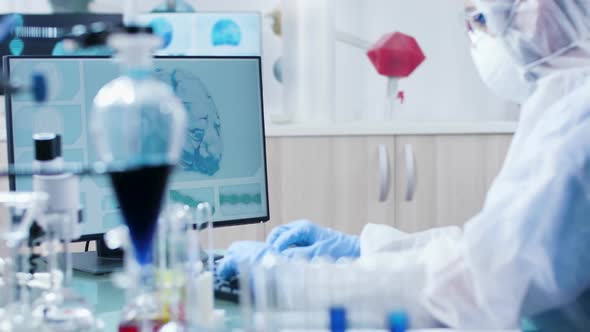 Modern Laboratory Scientist in Coverall Is Typing on Computer Keyboard