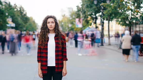 Lonely Girl Standing in City Center on Sidewalk Looking at Camera