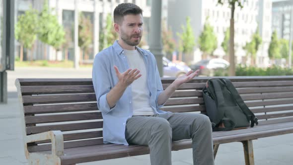 Tense Young Man Feeling Frustrated While Sitting on Bench