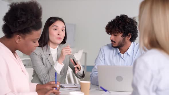 Young Asian Woman Telling Opinion Speaking to Multiethnic Diverse Colleagues