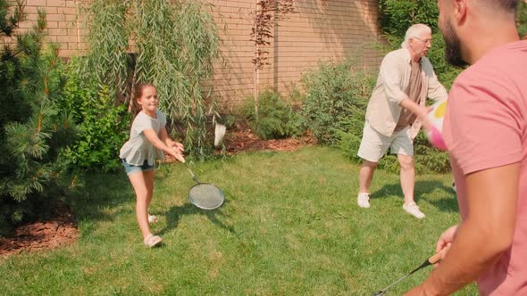 Family Playing Sports Outdoors In Backyard