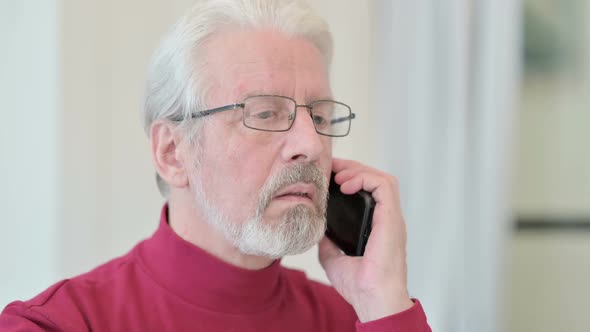 Close Up of Old Man Talking on Smartphone