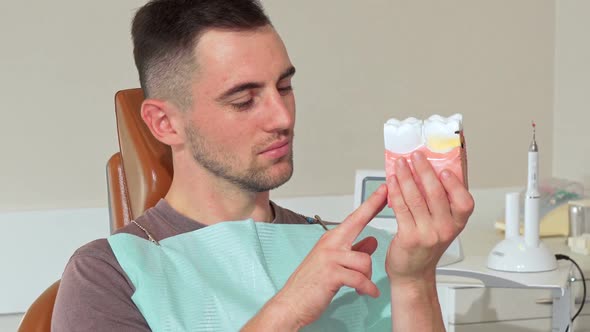 Handsome Young Man Smiling To the Camera Holding Dental Mold at the Clinic