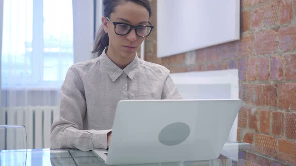 Hispanic Woman Working on Laptop in Office