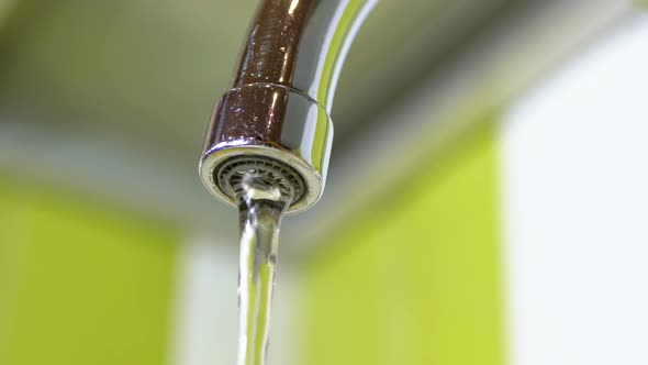 Water Running From the Tap Into a Sink