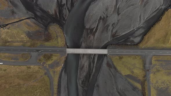 Aerial shot of a bridge crossing a glacial river system.