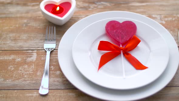 Close Up of Red Heart Shaped Lollipop on Plate