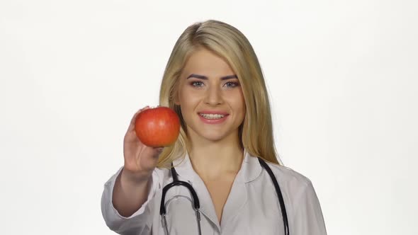 Doctor Shows a Red Apple on Camera. White