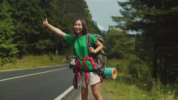 Lovely Asian Woman Backpacker Travelling By Autostop on Summer Vacations