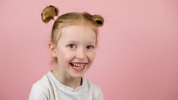 Funny Little Blonde Girl Smiling and Lughing on Pink Background