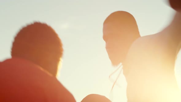 Two AfricanAmerican Athletes Train Together to Box Outdoors Against Background of Sunset