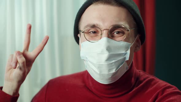 Closeup Face of Cheerful Young Man in Protective Mask Wearing Glasses Hat