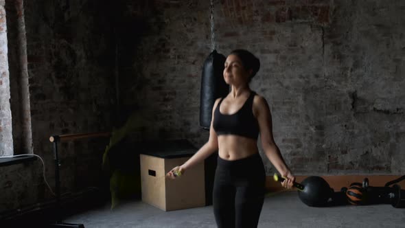 Young Indian Athletic Woman Doing Exercise Jumping Rope, Dressed in Sportswear Black Top 