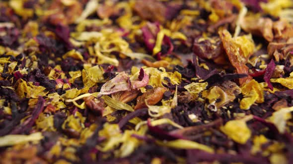 Dried leaves and petals of herbal flower tea with fruit pieces and hibiscus. Macro