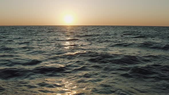 Aerial Top View of the Beautiful Waves of Fresh Sea Against Backdrop of the Sunset in Summer Season