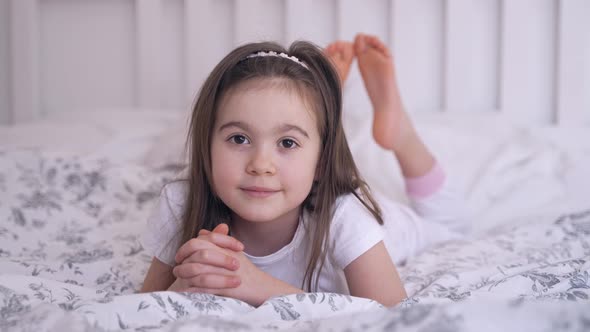 Barefoot Girl Resting on Bed