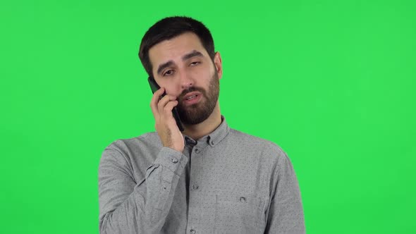 Portrait of Brunette Guy Is Talking for Mobile Phone. Green Screen