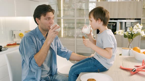 Man and His Son Drink Milk and Eat Cookies